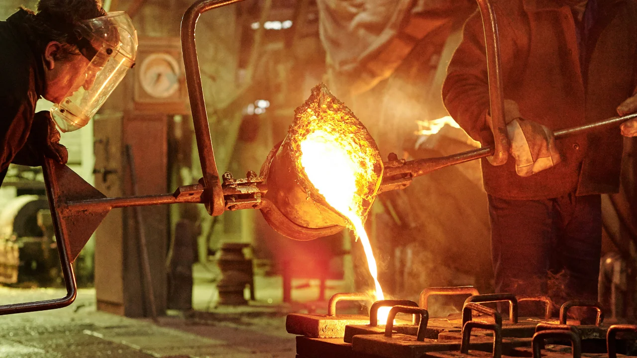 factory workers pour liquid metal
