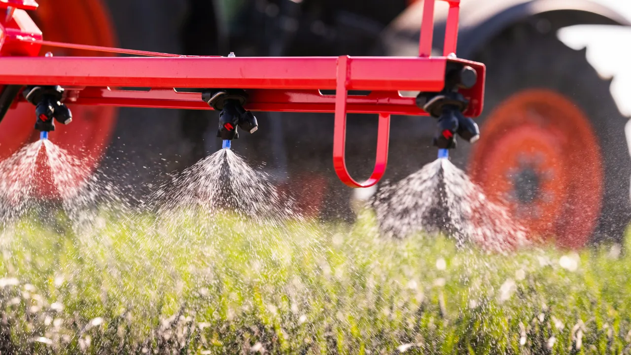 Tractor spraying fertilizer onto crops
