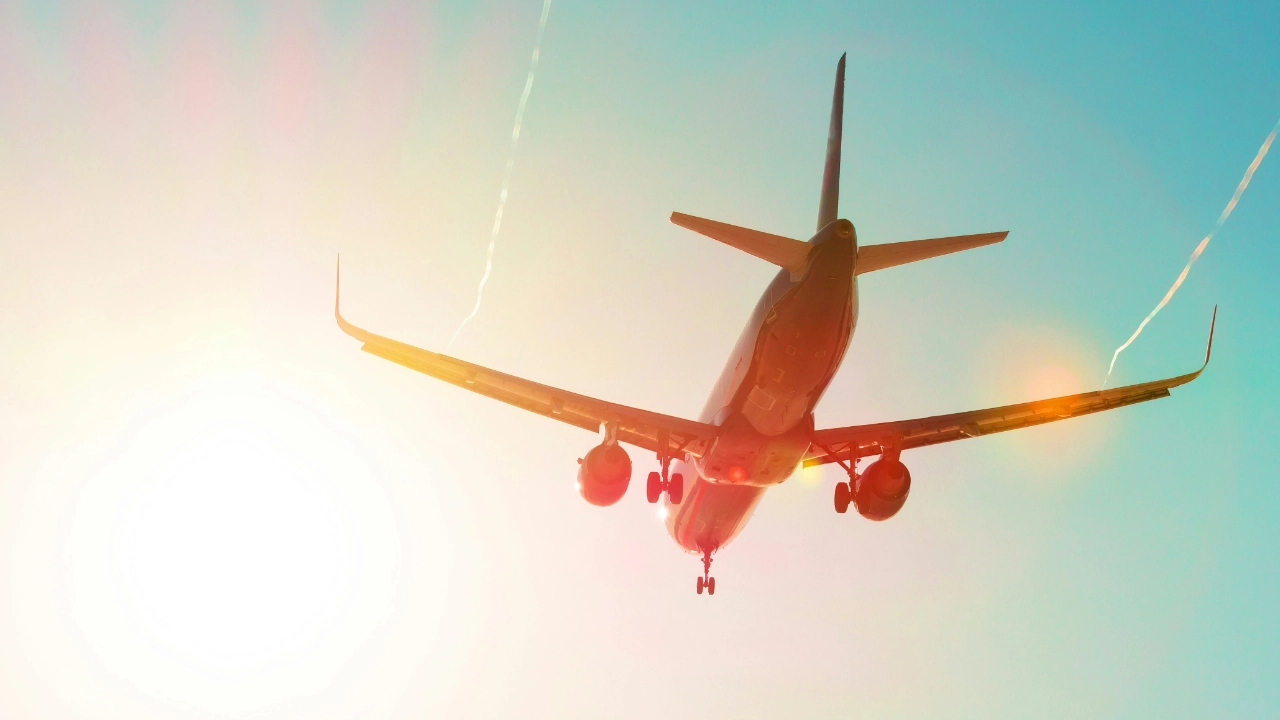 airplane flying into sunny sky