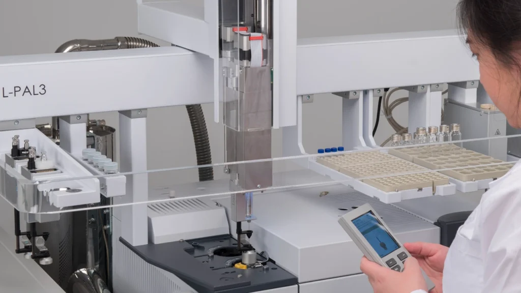 Chemist making adjustments to GC-MS autoloader