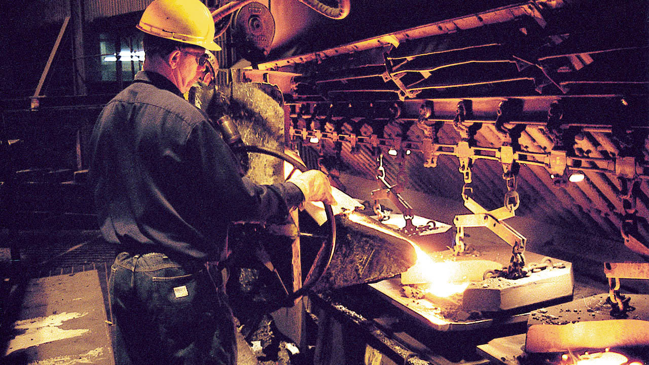 steel foundry worker pouring cast iron